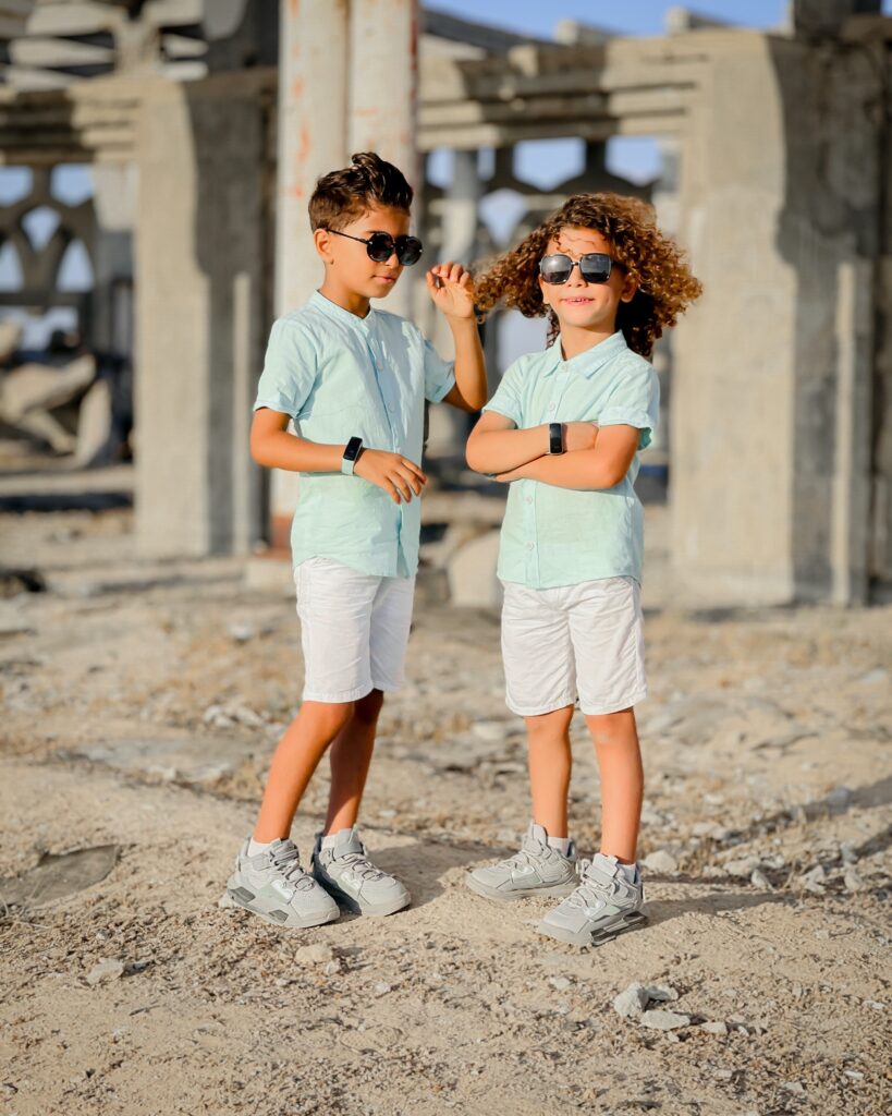 Twin boys standing in sun with sunglasses on