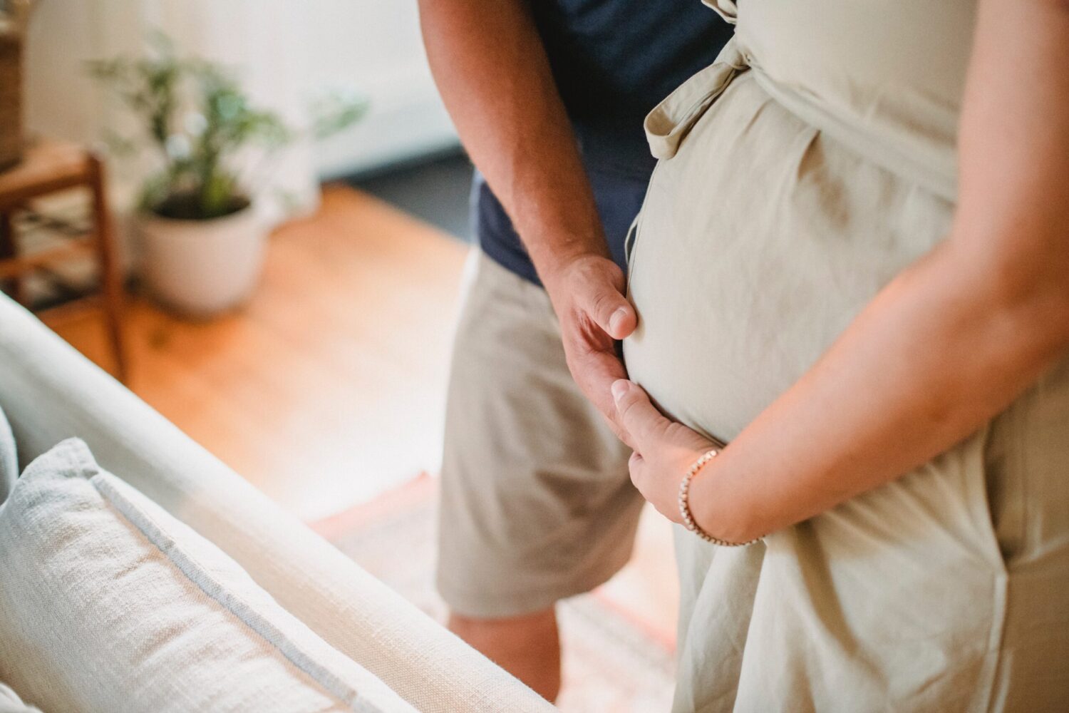 Man and woman with hands holding the woman's pregnant belly