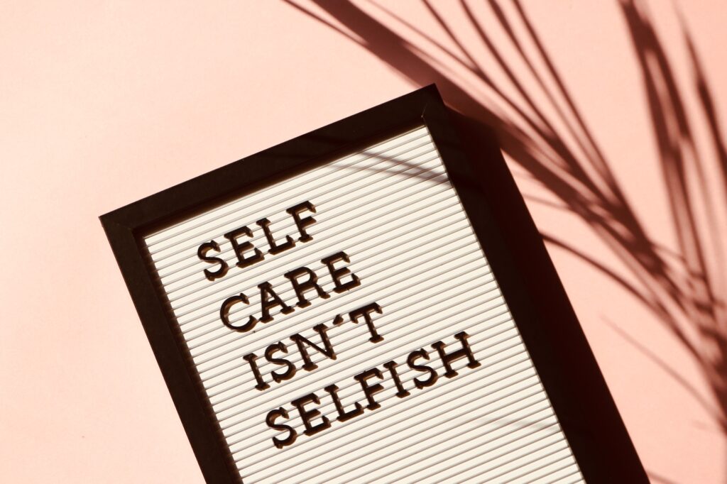 Text on a sign which reads "self care isn't selfish"