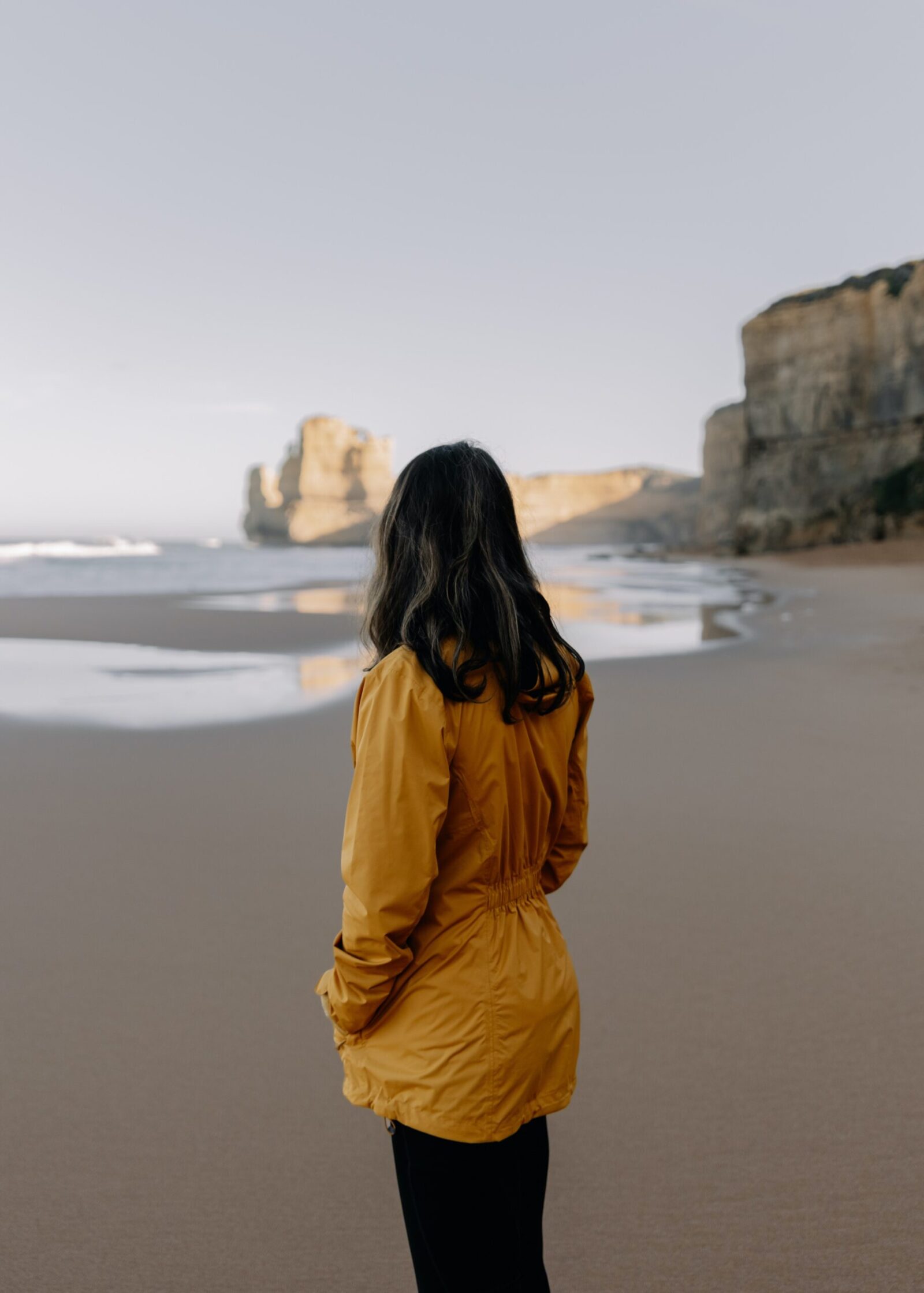 Woman standing on a beach looking at the sea